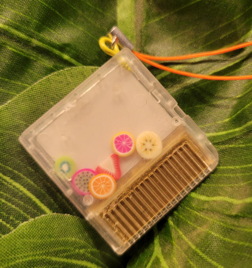 Back of the mini-shaker chip charm. casing and sticker modeled and sized in-house, outsourced for printing, returned to house for assembly. THE GOLD IS PAINTED SHRINKY DINK. CONTAINS NO MOTHERBOARD.